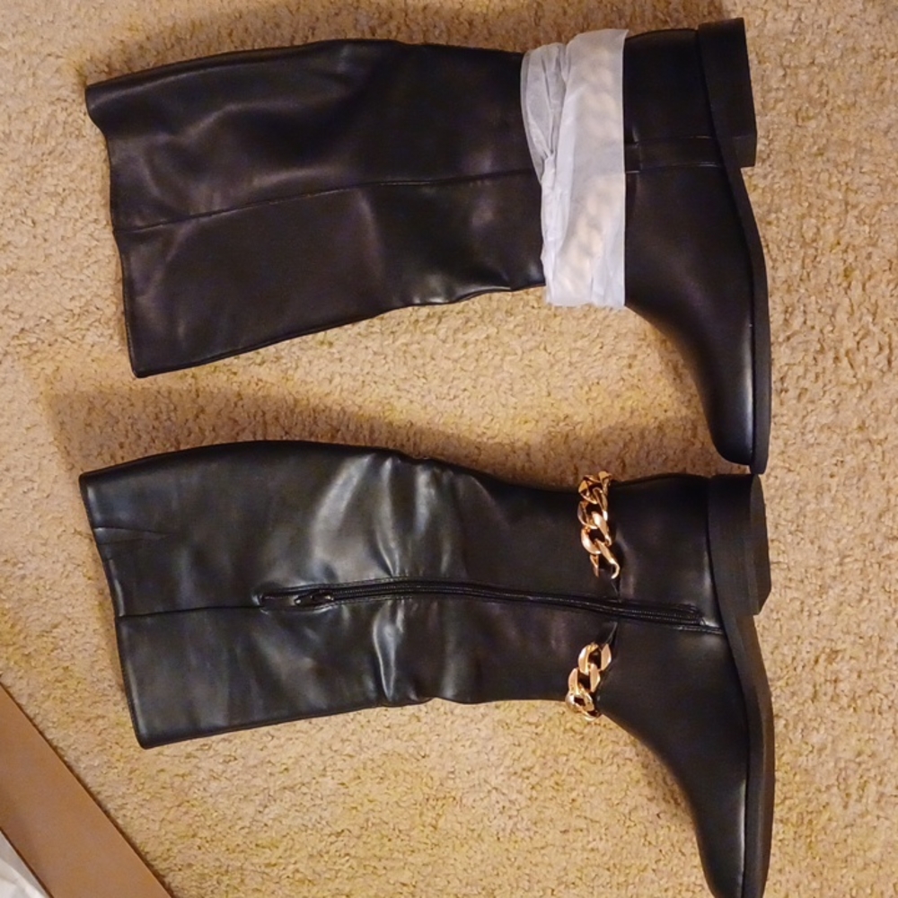 Size 9.5 black knee boots with gold chain around ankle.
